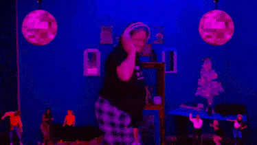 a woman in headphones is dancing in front of a disco ball with the words dang girl written on it