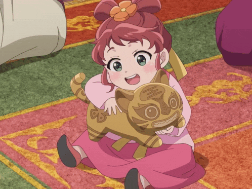 a little girl is sitting on a rug holding a stuffed animal