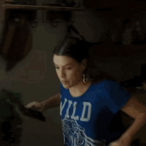 a woman in a blue shirt with the letter w on the front