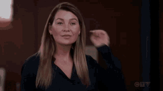 a woman is waving her hand in front of a camera .