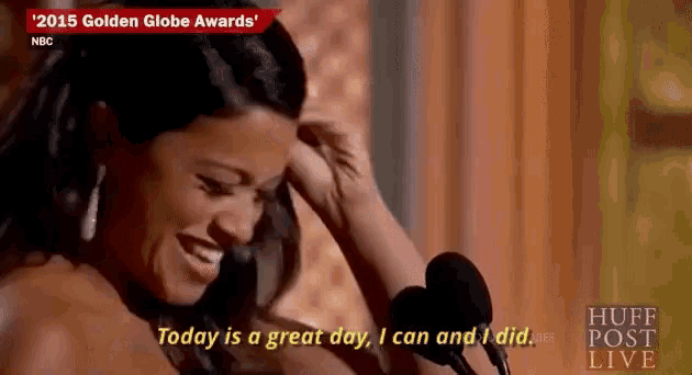 a woman is speaking into a microphone at the 2015 golden globe awards