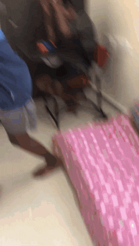 a blurry picture of people standing around a pink bed