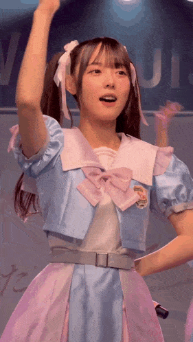 a girl in a blue and pink dress with a bow on her hair