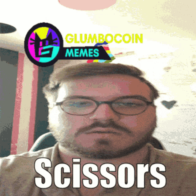a man with glasses and a beard says scissors on his face
