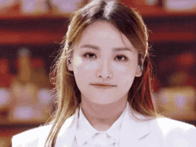 a close up of a woman 's face wearing a white shirt and jacket