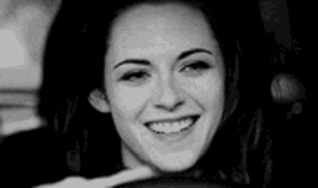 a black and white photo of a woman smiling .