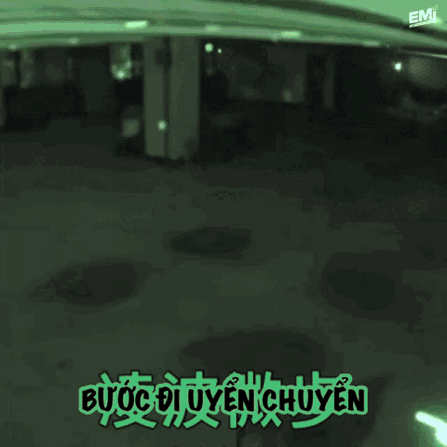 a man is standing in front of a window with the words buoc di uyen chuyen written in green
