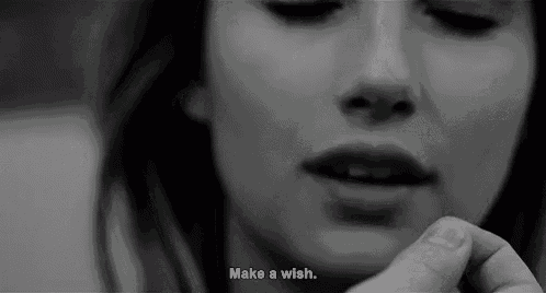 a black and white photo of a woman 's face with the words `` make a wish '' written below it .
