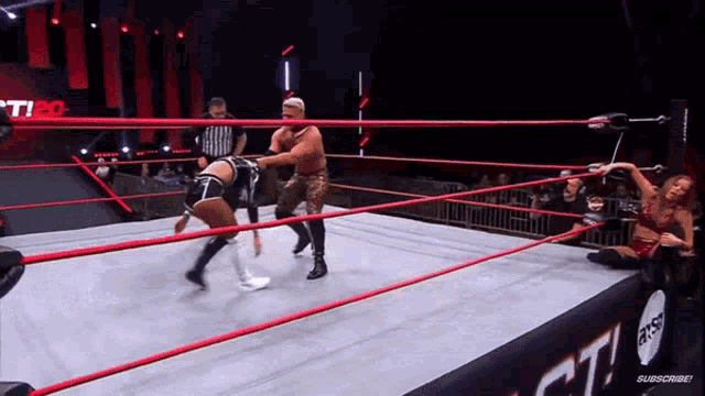 a man and a woman are wrestling in a ring .