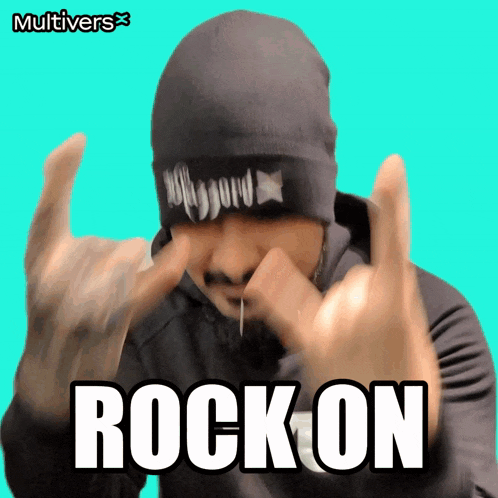 a man wearing a black beanie is making a rock on sign with his hands