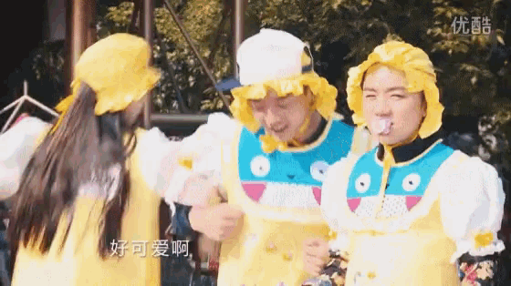 a group of people wearing yellow hats and dresses with chinese characters on them