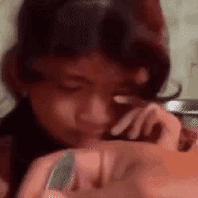 a close up of a person 's face with a blurred background .