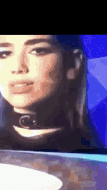 a close up of a woman 's face with a choker on her neck