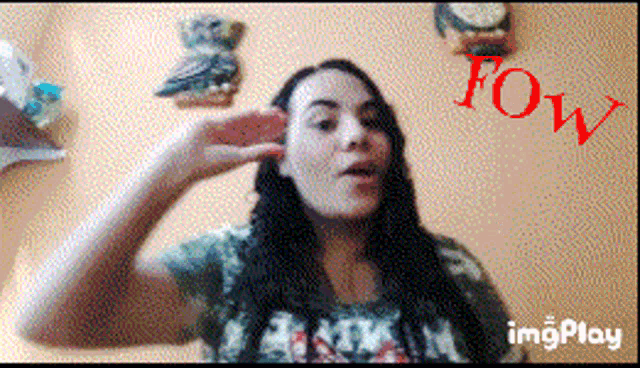 a woman covering her ear with her hand and the word fow is on the bottom