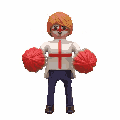 a playmobil cheerleader with a cross painted on his face is holding two red pom poms in his hands .