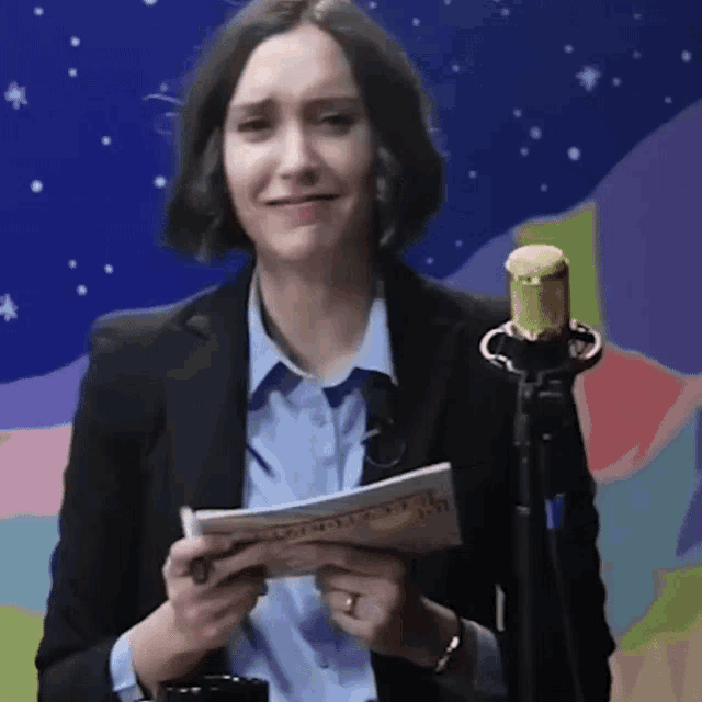 a woman in a suit is holding a piece of paper that says " i 'm sorry "