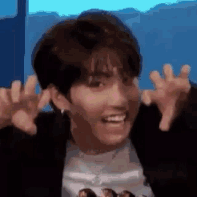 a close up of a person making a funny face with their arms outstretched .