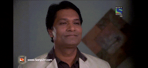 a man is smiling in front of a sony tv screen