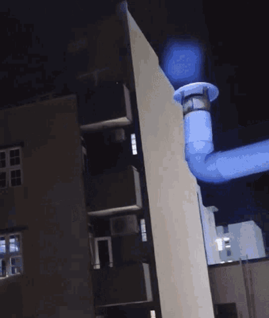 a blue pipe with a light on it is hanging from a building
