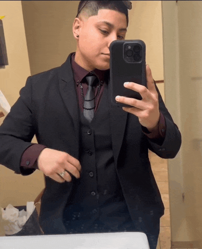 a man in a suit takes a selfie with his cell phone