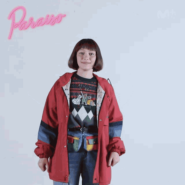 a woman in a red jacket is giving a thumbs up sign