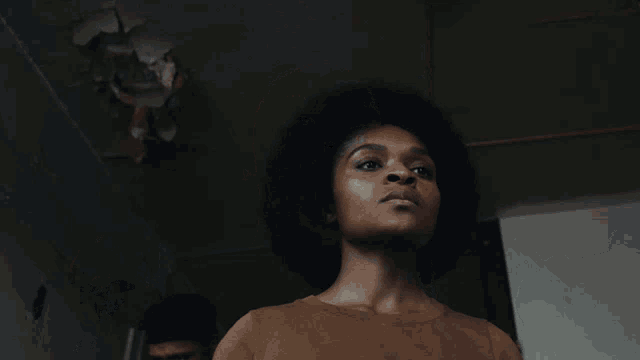 a close up of a woman 's face with a man in the background smoking a cigarette