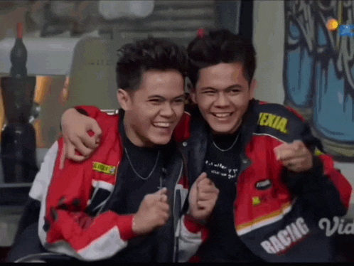 two young men are posing for a picture with one wearing a jacket that says racing