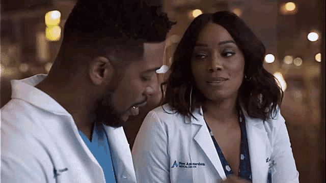 a man and a woman are standing next to each other and the woman is wearing a white coat that says mary anderson