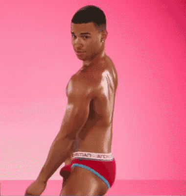a shirtless man is standing in front of a pink background wearing red underwear .