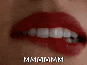 a close up of a woman 's mouth with red lipstick and white teeth with the words `` mmmm '' written below it .