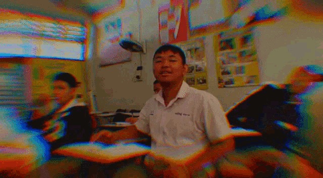 a boy in a classroom with a poster on the wall that says ' a '