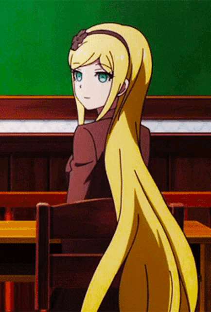 a girl with long blonde hair is sitting at a desk