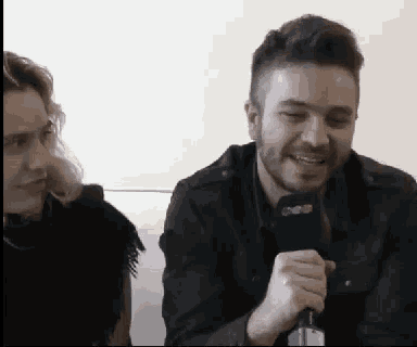 a man is holding a microphone in front of a woman .