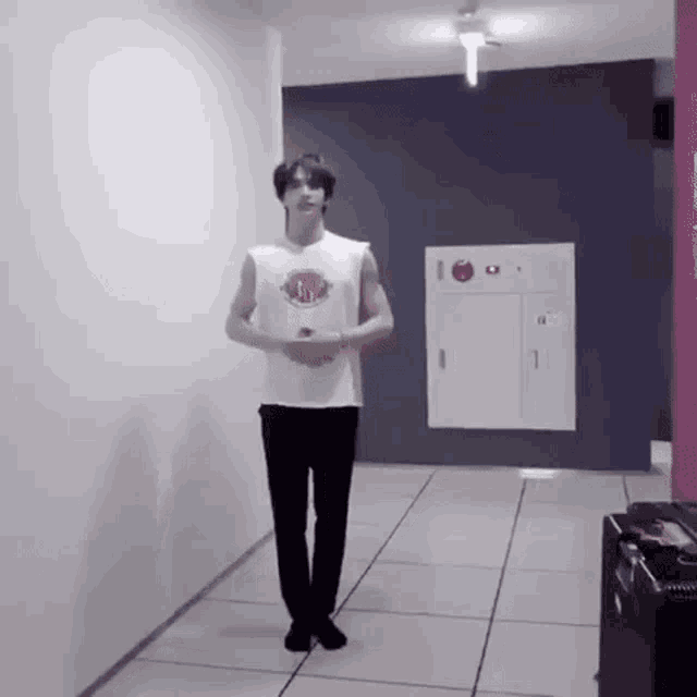 a man is standing in a hallway with his arms outstretched .