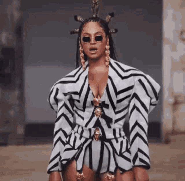 beyonce is wearing a black and white striped outfit with a crown on her head .
