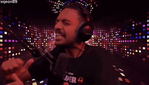 a man wearing headphones is singing into a microphone with the name xqeon89 visible in the corner