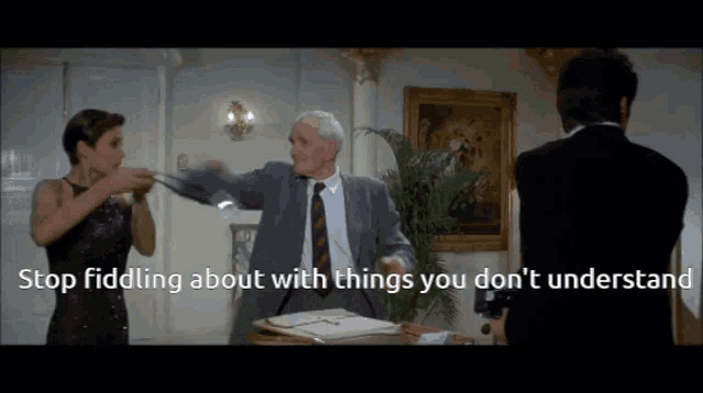a man in a suit and tie is talking to a woman and a man in a black suit