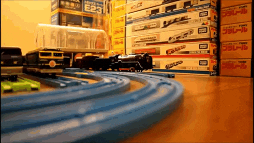 a stack of toy trains with boxes that say tomy on them