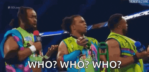 a group of men are standing next to each other on a stage and one of them is holding a microphone and asking who ?