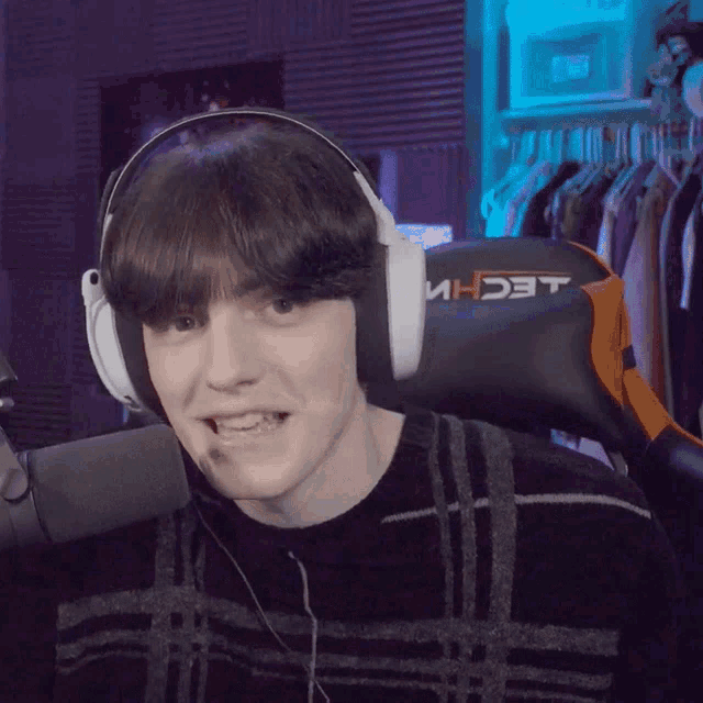 a man wearing headphones with the word techni on the back of his chair