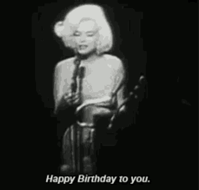 a black and white photo of a woman singing into a microphone and saying `` happy birthday to you '' .