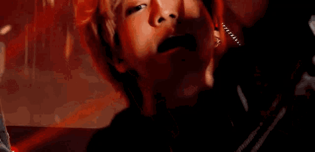 a close up of a person 's face with their mouth open and a red background .