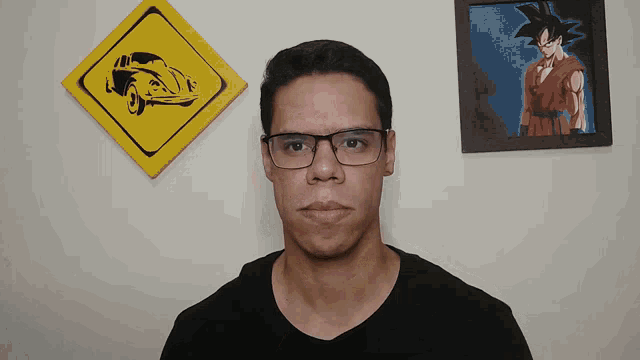 a man wearing glasses stands in front of a painting of a car
