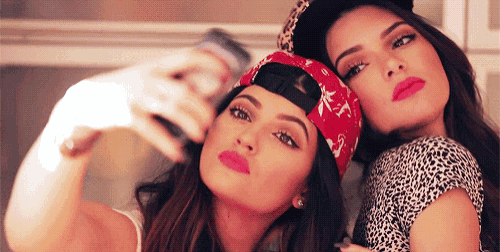 two girls are taking a selfie with their cell phones