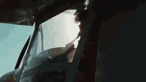 a man is sitting in the cockpit of a plane with a microphone on his head .