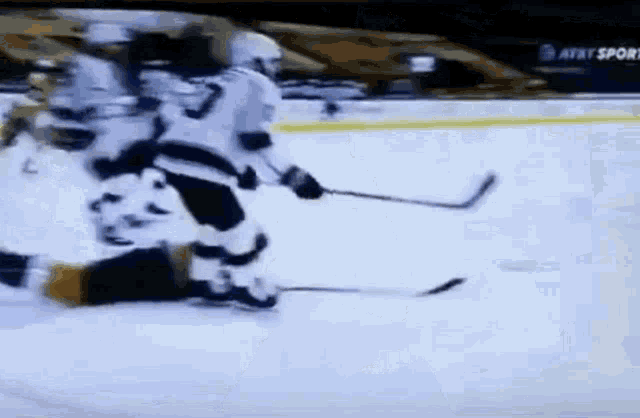 a hockey game is being played on a ice rink with at & t in the background .