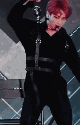 a man with red hair is standing on a stage with a microphone in his hand .