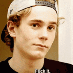 a young man wearing a hat and a black shirt is saying fuck it .
