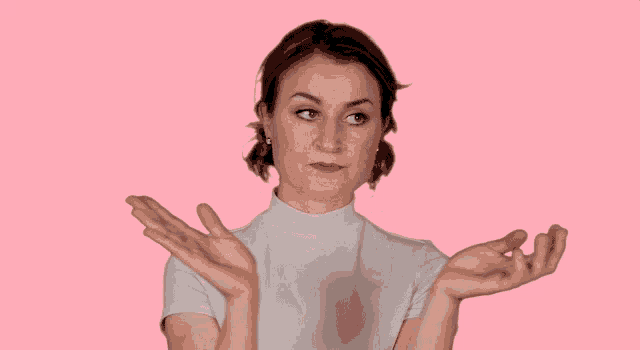 a woman in a white turtleneck is making a funny face with her hands outstretched