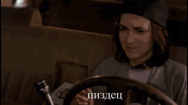 a woman behind a steering wheel with a foreign language written on the screen